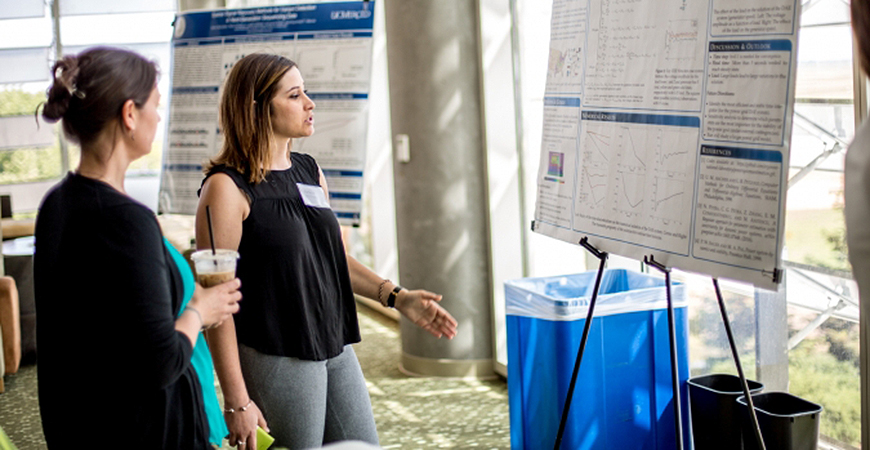 Undergraduate student presents her research poster. 